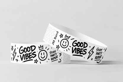 Two white paper wristbands with black printed doodle design