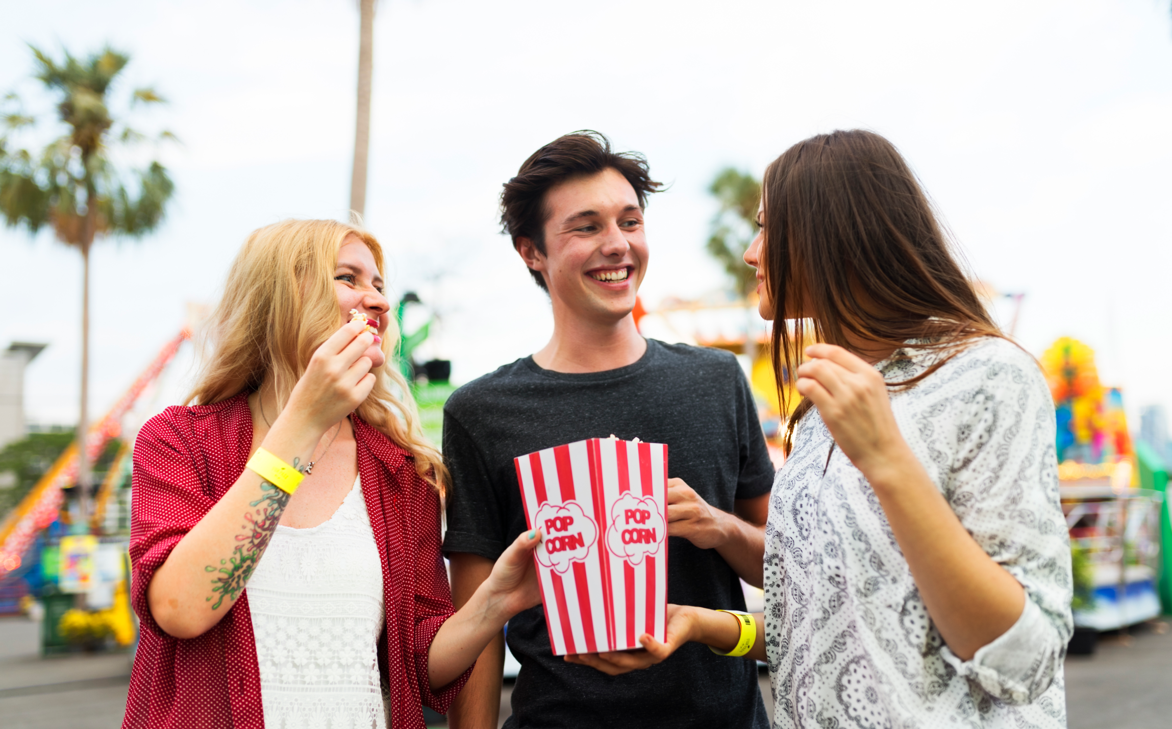 friends in amusement park eating popcorn